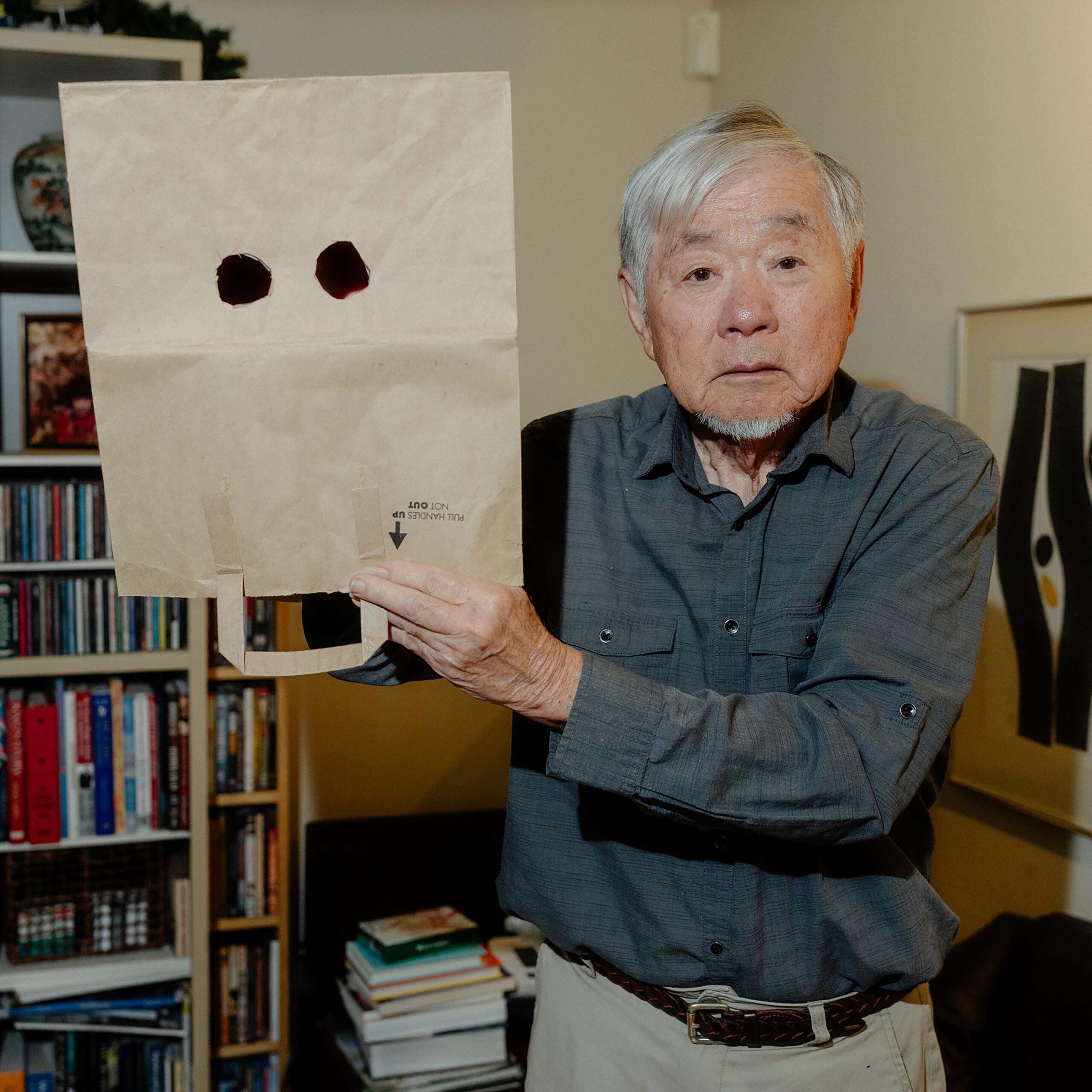 At his home in Sacramento, Calif., Lester Ouchida shows an example of how the women in his family shielded their faces while using the public latrine during incarceration.